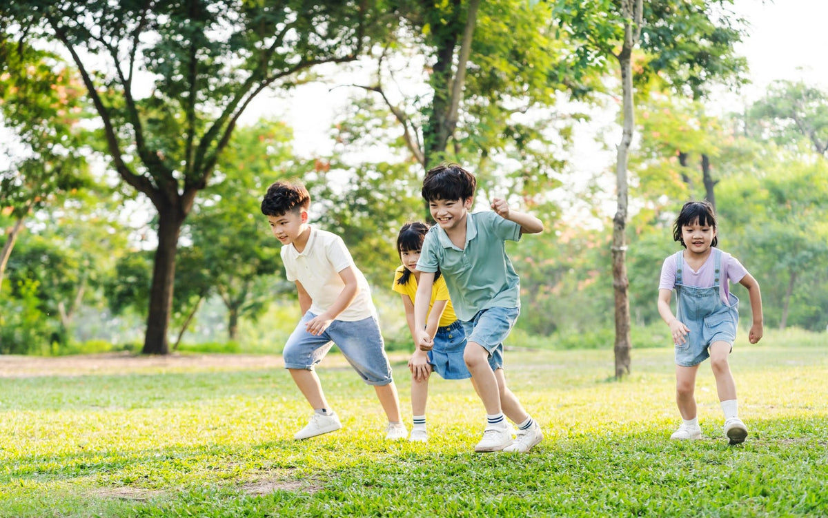 Children racing each other across the grass in a park