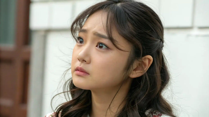 A young woman looking up with a worried expression, conscious of her receding hairline