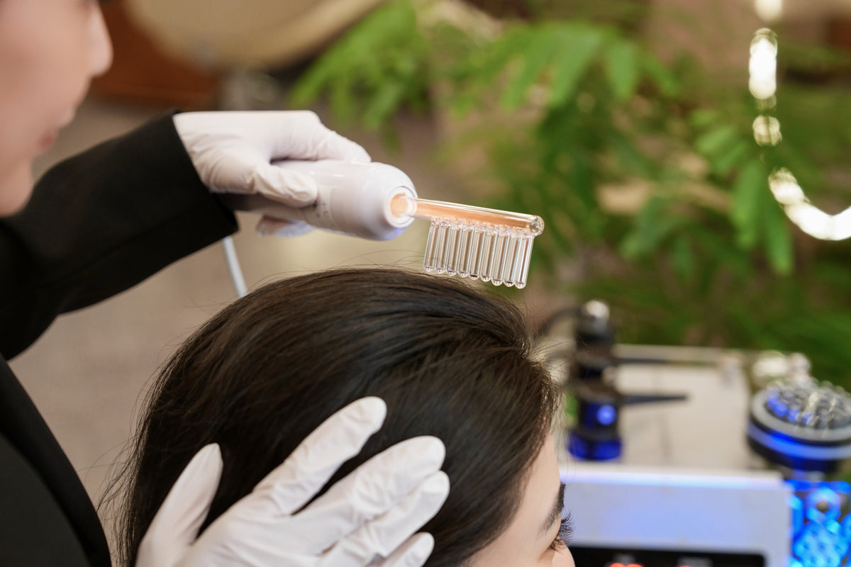A TrichoLab specialist combing through a client’s hair during a scalp treatment
