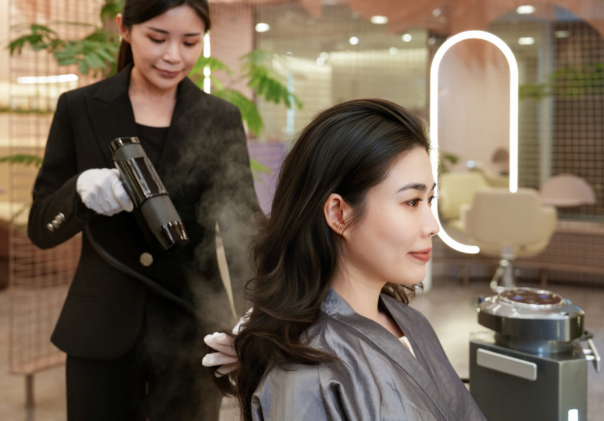 A TrichoLab specialist misting a treatment onto a client’s scalp