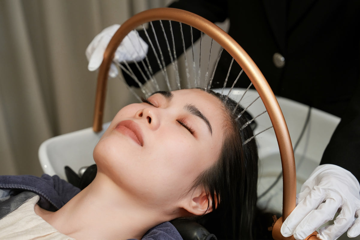 Warm water streaming over a guest's scalp during the TrichoLuxe Heavenly Head Spa at TrichoLab