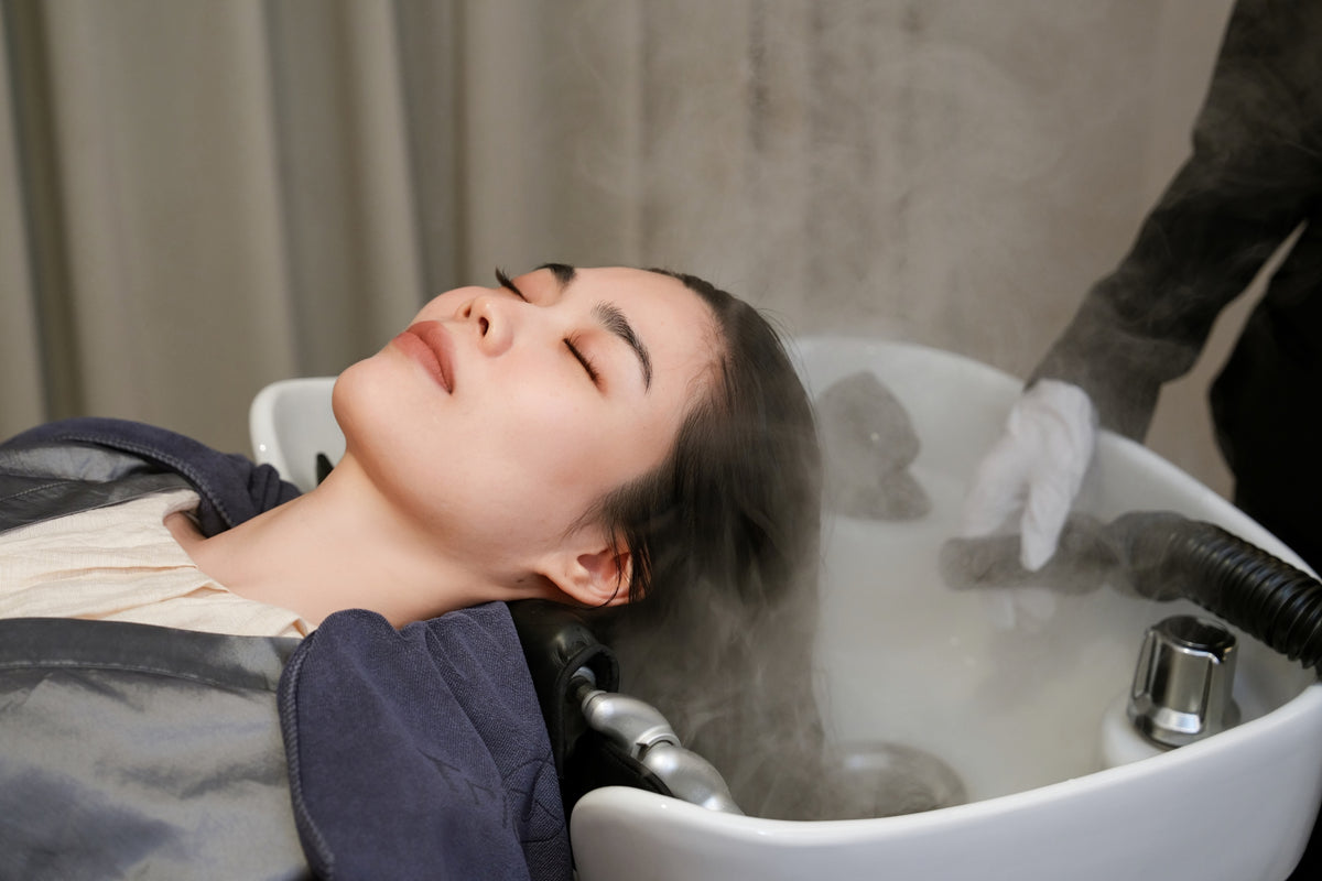 A client resting at the basin as steam rises during the Hydra Moisture Treatment