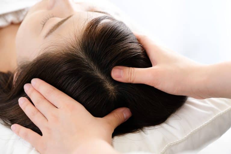 A woman getting a professional hair scalp massage