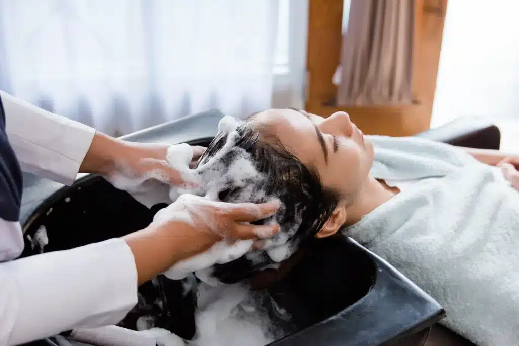 Girl getting a professional scalp treatment wash for dandruff